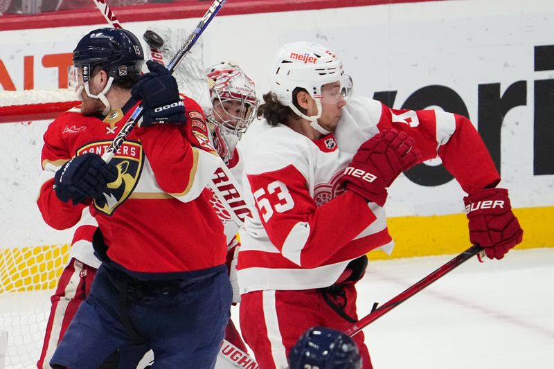 Jan 17, 2024; Sunrise, Florida, USA; Detroit Red Wings goaltender Alex Lyon (34) blocks a shot behind Florida Panthers left wing Matthew Tkachuk (19) and defenseman Moritz Seider (53) during the first period at Amerant Bank Arena. Mandatory Credit: Jasen Vinlove-USA TODAY Sports