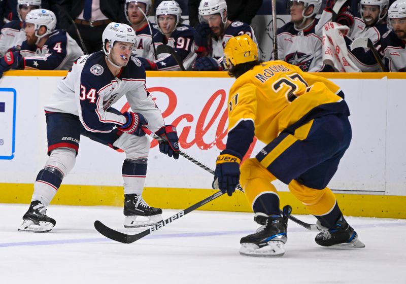 Jan 17, 2023; Nashville, Tennessee, USA;  Columbus Blue Jackets center Cole Sillinger (34) skates as Nashville Predators defenseman Ryan McDonagh (27) defends during the second period at Bridgestone Arena. Mandatory Credit: Steve Roberts-USA TODAY Sports