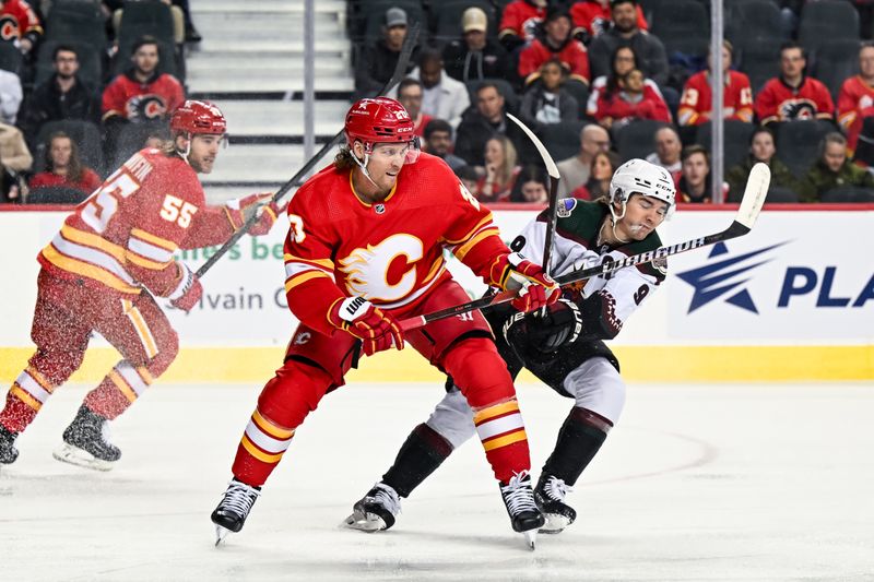 Jan 16, 2024; Calgary, Alberta, CAN; Calgary Flames center Blake Coleman (20) and Arizona Coyotes right wing Clayton Keller (9) compete for position during the first period at Scotiabank Saddledome. Mandatory Credit: Brett Holmes-USA TODAY Sports