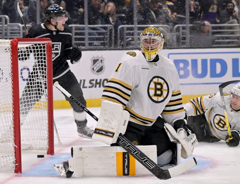 Oct 21, 2023; Los Angeles, California, USA; Los Angeles Kings right wing Alex Laferriere (left) reacts after scoring a goal against Boston Bruins goaltender Jeremy Swayman (1) and defenseman Brandon Carlo (right) during the second period at Crypto.com Arena. Mandatory Credit: Alex Gallardo-USA TODAY Sports