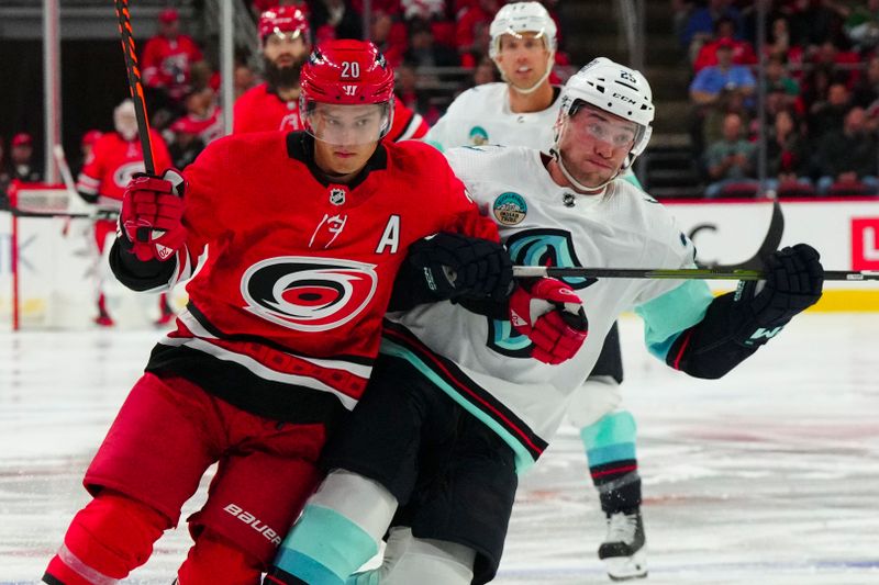 Oct 26, 2023; Raleigh, North Carolina, USA; Carolina Hurricanes center Sebastian Aho (20) and Seattle Kraken right wing Oliver Bjorkstrand (22) watch the play during the first period at PNC Arena. Mandatory Credit: James Guillory-USA TODAY Sports