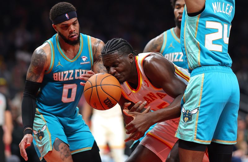 ATLANTA, GEORGIA - MARCH 23:  Clint Capela #15 of the Atlanta Hawks loses the ball out of bounds against Miles Bridges #0 and Brandon Miller #24 of the Charlotte Hornets during the second quarter at State Farm Arena on March 23, 2024 in Atlanta, Georgia.  NOTE TO USER: User expressly acknowledges and agrees that, by downloading and/or using this photograph, user is consenting to the terms and conditions of the Getty Images License Agreement.  (Photo by Kevin C. Cox/Getty Images)