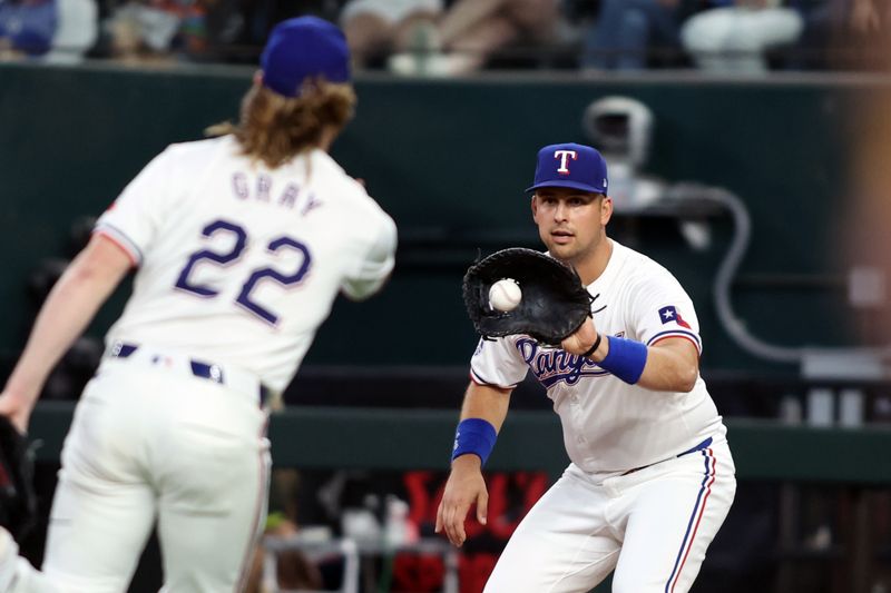 Jun 22, 2024; Arlington, Texas, USA; Texas Rangers pitcher Jon Gray (22) tosses the ball to first base Nathaniel Lowe (30) for the out in the game against the Kansas City Royals at Globe Life Field. Mandatory Credit: Tim Heitman-USA TODAY Sports