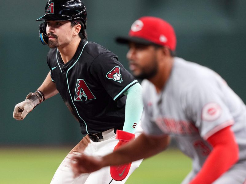 May 13, 2024; Phoenix, Arizona, USA; Arizona Diamondbacks outfielder Corbin Carroll (7) leads off first base as Cincinnati Reds third base Jeimer Candelario (3) covers the bag during the fourth inning at Chase Field. Mandatory Credit: Joe Camporeale-USA TODAY Sports