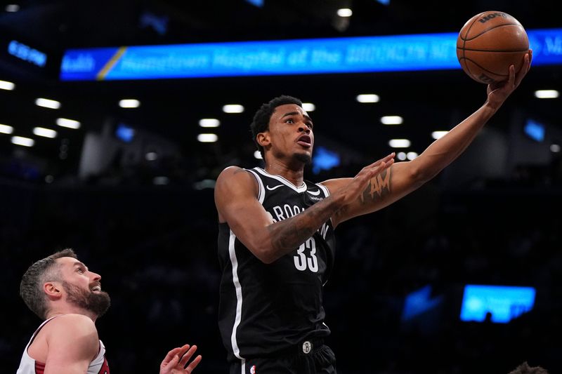 NEW YORK, NEW YORK - NOVEMBER 25: Nic Claxton #33 of the Brooklyn Nets shoots the ball against Kevin Love #42 of the Miami Heat in the first half at Barclays Center on November 25, 2023 in the Brooklyn borough of New York City. NOTE TO USER: User expressly acknowledges and agrees that, by downloading and or using this photograph, User is consenting to the terms and conditions of the Getty Images License Agreement. (Photo by Mitchell Leff/Getty Images)