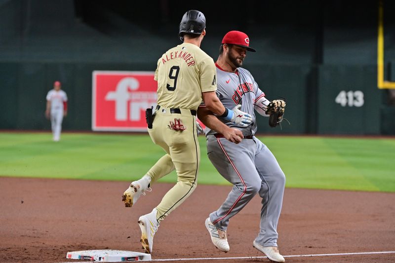 May 14, 2024; Phoenix, Arizona, USA;  Arizona Diamondbacks shortstop Blaze Alexander (9) collides with Cincinnati Reds first base Mike Ford (38) after being forced out in the first inning at Chase Field. Mandatory Credit: Matt Kartozian-USA TODAY Sports