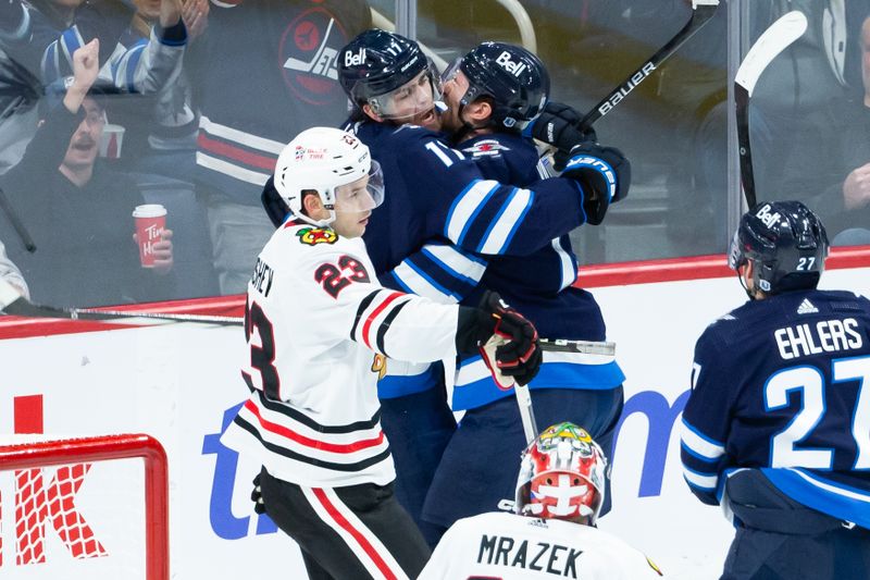 Jan 11, 2024; Winnipeg, Manitoba, CAN; Winnipeg Jets forward Gabriel Vilardi (13) is congratulated by Winnipeg Jets forward Adam Lowry (17) on his goal against Chicago Blackhawks goalie Petr Mrazek (34) during the third period at Canada Life Centre. Mandatory Credit: Terrence Lee-USA TODAY Sports