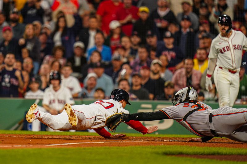 Sep 9, 2024; Boston, Massachusetts, USA; Boston Red Sox right fielder Rob Refsnyder (30) tagged out at home plate by Baltimore Orioles catcher Adley Rutschman (35) in the fifth inning at Fenway Park. Mandatory Credit: David Butler II-Imagn Images