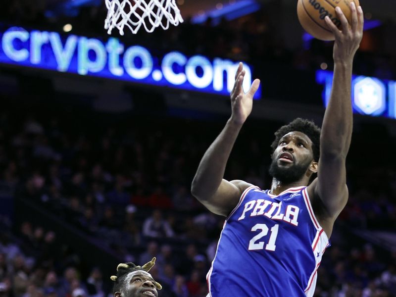 PHILADELPHIA, PENNSYLVANIA - MARCH 29: Joel Embiid #21 of the Philadelphia 76ers shoots a lay up past Reggie Bullock #25 of the Dallas Mavericks during the second quarter  at Wells Fargo Center on March 29, 2023 in Philadelphia, Pennsylvania. NOTE TO USER: User expressly acknowledges and agrees that, by downloading and or using this photograph, User is consenting to the terms and conditions of the Getty Images License Agreement. (Photo by Tim Nwachukwu/Getty Images)