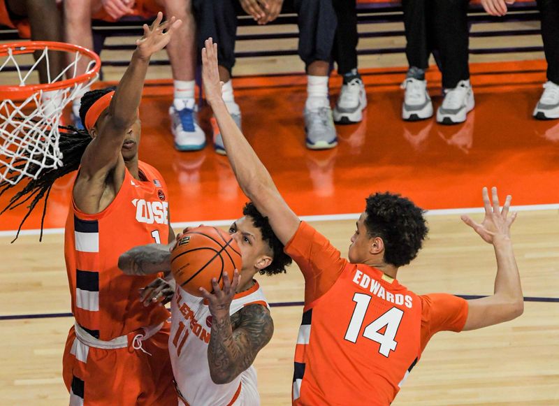 Feb 22, 2023; Clemson, South Carolina, USA; Clemson guard Brevin Galloway (11) shoots against Syracuse forward Maliq Brown (1) and Syracuse center Jesse Edwards (14) during the first half at Littlejohn Coliseum. Mandatory Credit: Ken Ruinard-USA TODAY Sports