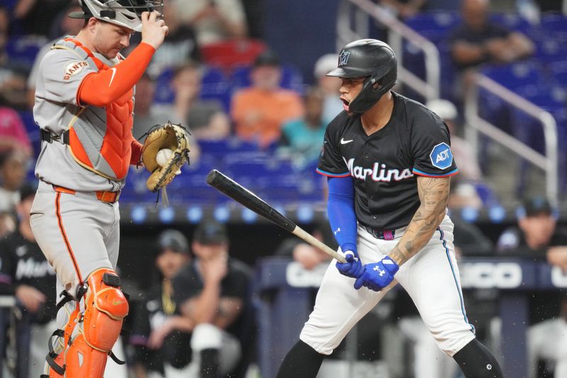 May 30, 2025; Miami, Florida, USA;  Miami Marlins designated hitter Agustín Ramírez (50) disagrees with the strike three call that ended the game as San Francisco Giants catcher Patrick Bailey (14) looks on at loanDepot Park. Mandatory Credit: Jim Rassol-Imagn Images