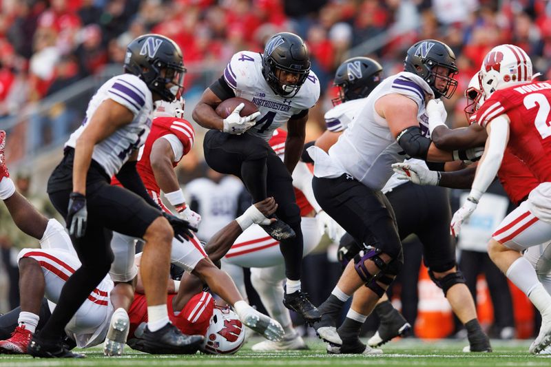 Nov 11, 2023; Madison, Wisconsin, USA;  Northwestern Wildcats running back Cam Porter (4) rushes with the football during the second quarter against the Wisconsin Badgers at Camp Randall Stadium. Mandatory Credit: Jeff Hanisch-USA TODAY Sports