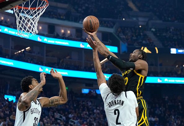 SAN FRANCISCO, CALIFORNIA - DECEMBER 16: Jonathan Kuminga #00 of the Golden State Warriors drives to the basket on Cameron Johnson #2 of the Brooklyn Nets during the first quarter of an NBA basketball game at Chase Center on December 16, 2023 in San Francisco, California. NOTE TO USER: User expressly acknowledges and agrees that, by downloading and or using this photograph, User is consenting to the terms and conditions of the Getty Images License Agreement. (Photo by Thearon W. Henderson/Getty Images)