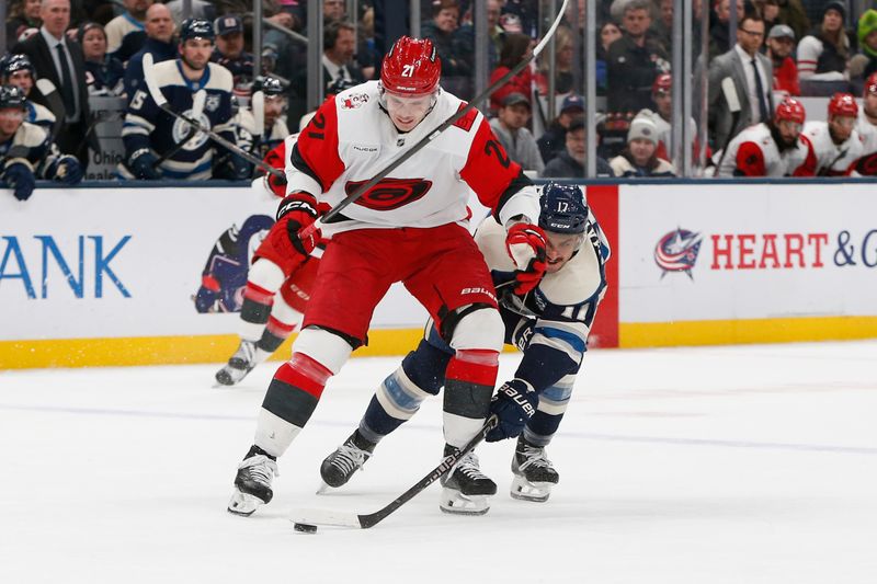 Mar 17, 2026; Columbus, Ohio, USA; Columbus Blue Jackets left wing Mason Marchment (17) steals the puck away from Carolina Hurricanes defenseman Alexander Nikishin (21) during the second period at Nationwide Arena. Mandatory Credit: Russell LaBounty-Imagn Images