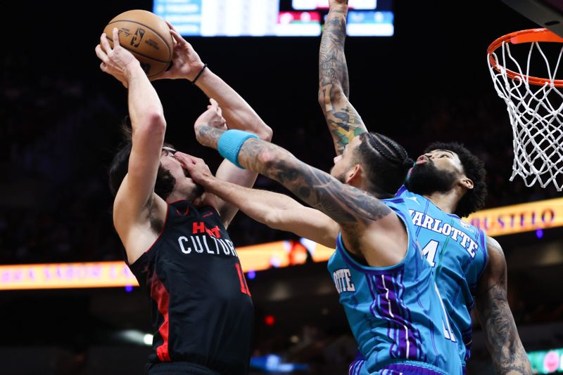 MIAMI, FLORIDA - JANUARY 14: Jaime Jaquez Jr. #11 of the Miami Heat drives against Cody Martin #11 and Nick Richards #4 of the Charlotte Hornets during the first quarter at Kaseya Center on January 14, 2024 in Miami, Florida. NOTE TO USER: User expressly acknowledges and agrees that, by downloading and or using this photograph, User is consenting to the terms and conditions of the Getty Images License Agreement.  (Photo by Megan Briggs/Getty Images)