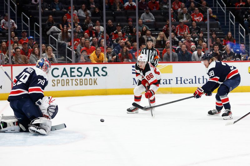 Feb 20, 2024; Washington, District of Columbia, USA; Washington Capitals goaltender Charlie Lindgren (79) makes a save on New Jersey Devils center Jack Hughes (86) as Capitals defenseman Rasmus Sandin (38) defends in the first period at Capital One Arena. Mandatory Credit: Geoff Burke-USA TODAY Sports