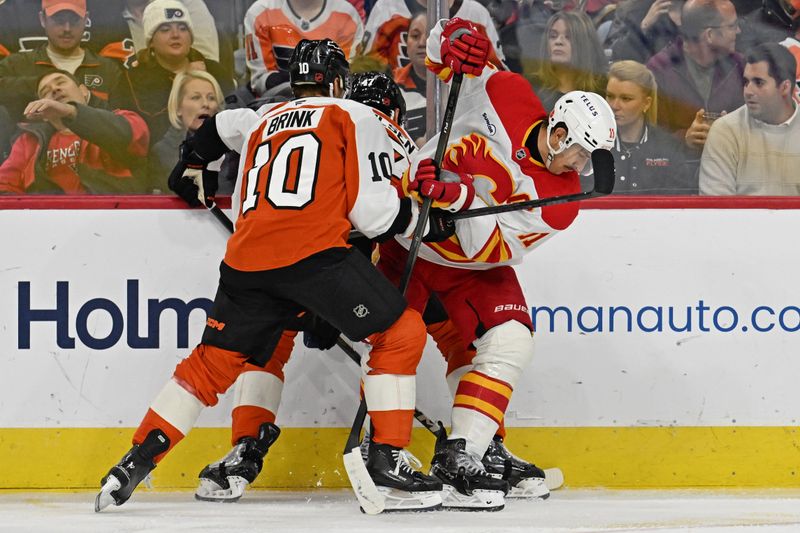 Nov 2, 2025; Philadelphia, Pennsylvania, USA; Calgary Flames center Mikael Backlund (11) battle for the puck iwyth Philadelphia Flyers right wing Bobby Brink (10) during the third period at Xfinity Mobile Arena. Mandatory Credit: Eric Hartline-Imagn Images
