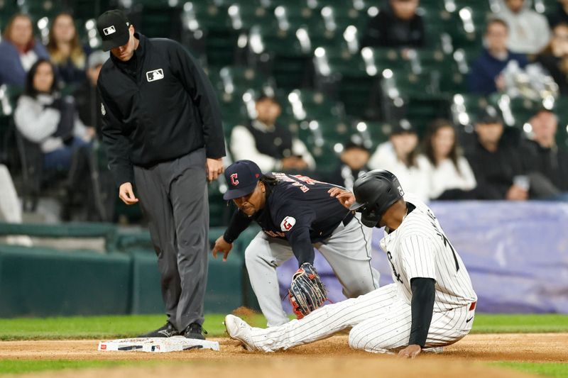 May 9, 2024; Chicago, Illinois, USA; Chicago White Sox designated hitter Eloy Jimenez (74) is caught stealing third base by Cleveland Guardians third baseman Jose Ramirez (11) during the third inning at Guaranteed Rate Field. Mandatory Credit: Kamil Krzaczynski-USA TODAY Sports