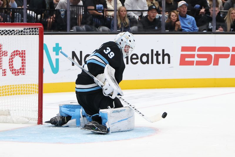 Oct 8, 2024; Salt Lake City, Utah, USA; Utah Hockey Club goaltender Connor Ingram (39) blocks a shot against the Chicago Blackhawks during the third period at Delta Center. Mandatory Credit: Rob Gray-Imagn Images