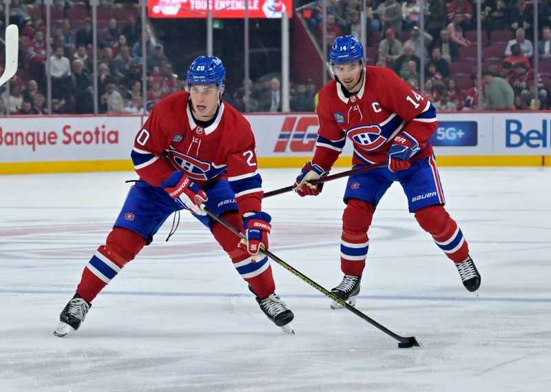 Oct 9, 2024; Montreal, Quebec, CAN; Montreal Canadiens forward Juraj Slafkovsky (20) plays the puck ahead of teammate forward Nick Suzuki (14) during the second period at the Bell Centre. Mandatory Credit: Eric Bolte-Imagn Images