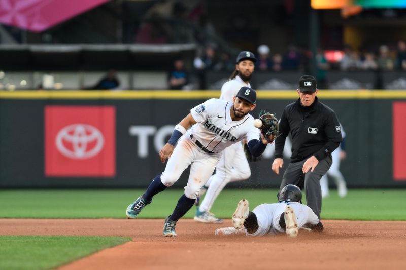 Jun 14, 2023; Seattle, Washington, USA; Miami Marlins shortstop Jon Berti (5) slides under Seattle Mariners second baseman Jose Caballero (76) to steal second base during the seventh inning at T-Mobile Park. Mandatory Credit: Steven Bisig-USA TODAY Sports