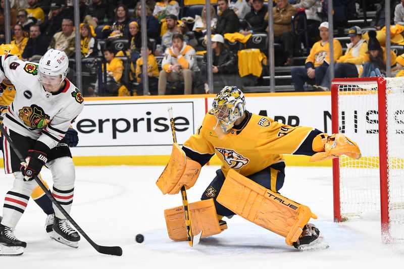 Jan 2, 2024; Nashville, Tennessee, USA; Nashville Predators goaltender Juuse Saros (74) makes a save with a screen from Chicago Blackhawks center Ryan Donato (8) during the second period at Bridgestone Arena. Mandatory Credit: Christopher Hanewinckel-USA TODAY Sports