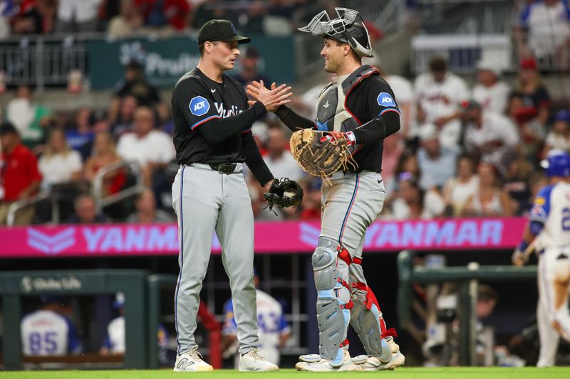 Aug 3, 2024; Atlanta, Georgia, USA; Miami Marlins relief pitcher Calvin Faucher (53) and catcher Nick Fortes (4) celebrate after a victory over the Atlanta Braves at Truist Park. Mandatory Credit: Brett Davis-USA TODAY Sports