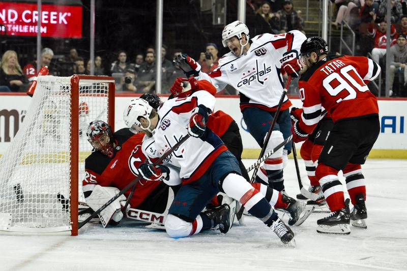 Oct 19, 2024; Newark, New Jersey, USA; Washington Capitals right wing Taylor Raddysh (16) tries to shoot the puck against New Jersey Devils goaltender Jacob Markstrom (25) during the third period at Prudential Center. Mandatory Credit: John Jones-Imagn Images