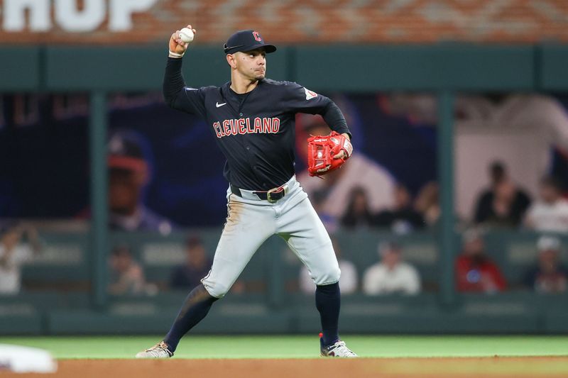 Apr 27, 2024; Atlanta, Georgia, USA; Cleveland Guardians second baseman Andres Gimenez (0) throws a runner out at first against the Atlanta Braves in the seventh inning at Truist Park. Mandatory Credit: Brett Davis-USA TODAY Sports