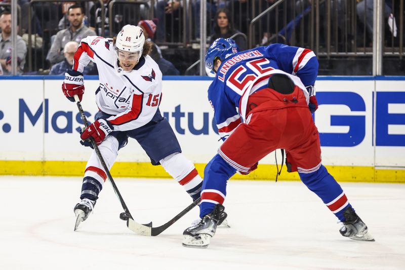 Apr 21, 2024; New York, New York, USA; Washington Capitals left wing Sonny Milano (15) and New York Rangers defenseman Ryan Lindgren (55) battle for control of the puck in game one of the first round of the 2024 Stanley Cup Playoffs at Madison Square Garden. Mandatory Credit: Wendell Cruz-USA TODAY Sports