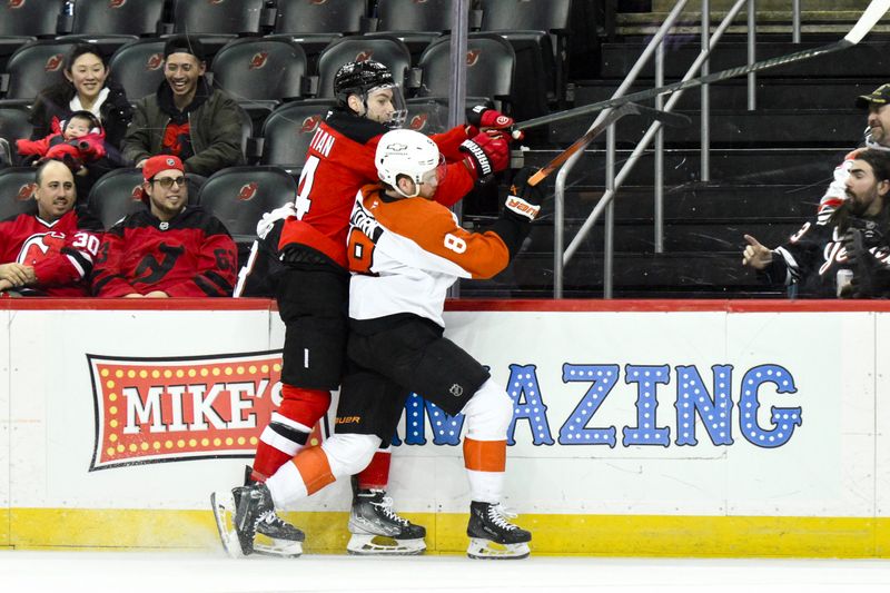 Jan 29, 2025; Newark, New Jersey, USA; New Jersey Devils right wing Nathan Bastian (14) and Philadelphia Flyers defenseman Cam York (8) battle along the boards during the third period at Prudential Center. Mandatory Credit: John Jones-Imagn Images