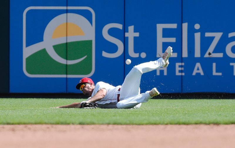 Aug 20, 2023; Cincinnati, Ohio, USA; Cincinnati Reds right fielder TJ Hopkins (26) misses a ball against the Toronto Blue Jays during the ninth inning at Great American Ball Park. Mandatory Credit: David Kohl-USA TODAY Sports