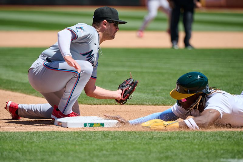 May 5, 2024; Oakland, California, USA; Oakland Athletics outfielder Lawrence Butler (4) slides safely into third base on a pickoff attempt against Miami Marlins infielder Jonah Bride (41 during the fourth inning at Oakland-Alameda County Coliseum. Mandatory Credit: Robert Edwards-USA TODAY Sports