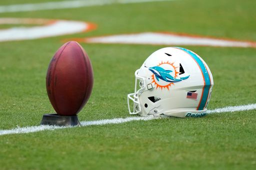 A helmet belonging to Miami Dolphins place kicker Jason Sanders and a ball are shown on the field before the start of an NFL football game against the New York Jets, Sunday, Dec. 8, 2024, in Miami Gardens, Fla. (AP Photo/Wilfredo Lee)