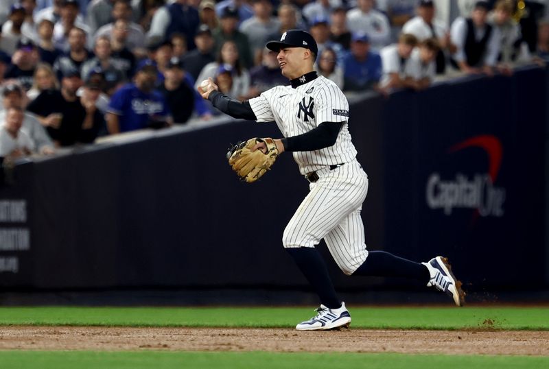 Oct 30, 2024; New York, New York, USA; New York Yankees shortstop Anthony Volpe (11) makes a throwing error during the fifth inning against the Los Angeles Dodgers in game five of the 2024 MLB World Series at Yankee Stadium. Mandatory Credit: Vincent Carchietta-Imagn Images