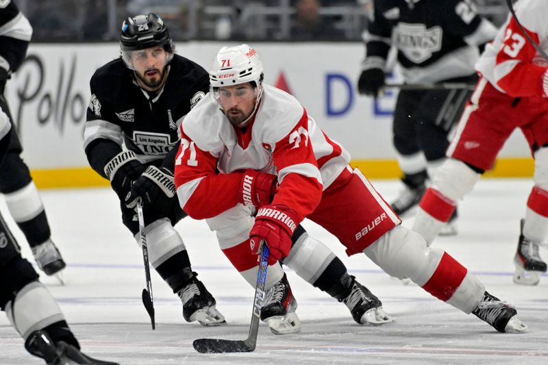 Nov 16, 2024; Los Angeles, California, USA; Detroit Red Wings center Dylan Larkin (71) controls the puck from Los Angeles Kings center Phillip Danault (24) in the third period at Crypto.com Arena. Mandatory Credit: Jayne Kamin-Oncea-Imagn Images