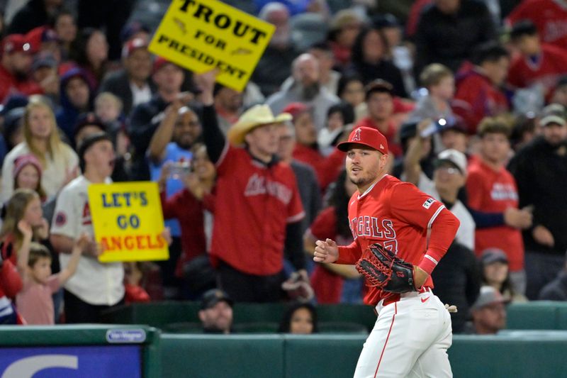 Apr 6, 2024; Anaheim, California, USA; Los Angeles Angels outfielder Mike Trout (27) jogs to the dugout after making a leaping catch at the wall off a fly ball hit by Boston Red Sox outfielder Jarren Duran (16) in the eighth inning at Angel Stadium. Mandatory Credit: Jayne Kamin-Oncea-USA TODAY Sports