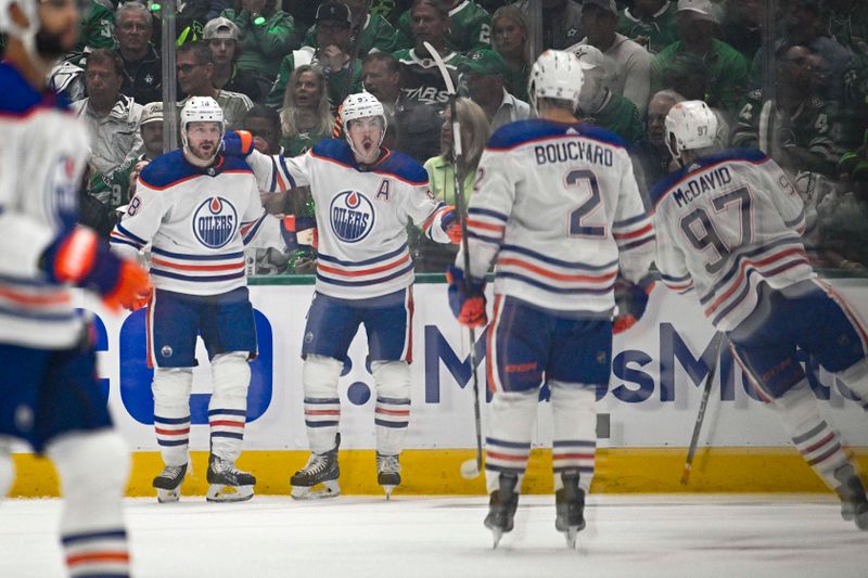 May 23, 2024; Dallas, Texas, USA; Edmonton Oilers left wing Zach Hyman (18) and center Connor McDavid (97) and center Ryan Nugent-Hopkins (93) and defenseman Evan Bouchard (2) celebrates a goal scored by Hyman against the Dallas Stars during the second period in game one of the Western Conference Final of the 2024 Stanley Cup Playoffs at American Airlines Center. Mandatory Credit: Jerome Miron-USA TODAY Sports