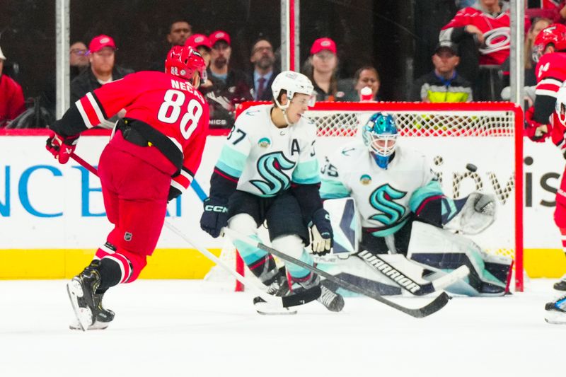 Oct 26, 2023; Raleigh, North Carolina, USA; Carolina Hurricanes center Martin Necas (88) scores the game winner in the over time past Seattle Kraken goaltender Joey Daccord (35) and center Yanni Gourde (37) at PNC Arena. Mandatory Credit: James Guillory-USA TODAY Sports