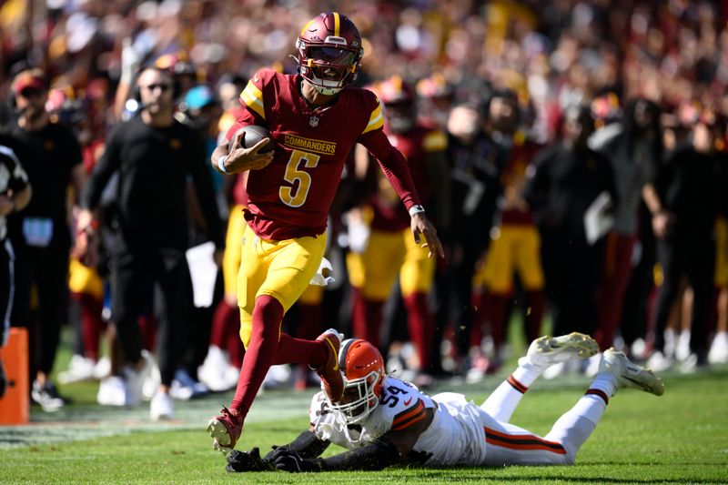 Washington Commanders quarterback Jayden Daniels (5) runs past Cleveland Browns defensive end Ogbo Okoronkwo (54) during the first half of an NFL football game in Landover, Md., Sunday, Oct. 6, 2024. (AP Photo/Nick Wass)