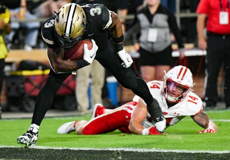 Sep 22, 2023; West Lafayette, Indiana, USA; Purdue Boilermakers running back Tyrone Tracy Jr. (3) evades a tackle from Wisconsin Badgers safety Preston Zachman (14) on his way to scoring a touchdown during the second half at Ross-Ade Stadium. Mandatory Credit: Robert Goddin-USA TODAY Sports