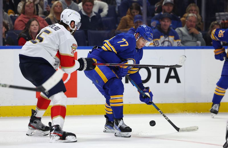 Oct 28, 2024; Buffalo, New York, USA;  Florida Panthers defenseman Aaron Ekblad (5) and Buffalo Sabres right wing JJ Peterka (77) go after a loose puck during the second period at KeyBank Center. Mandatory Credit: Timothy T. Ludwig-Imagn Images