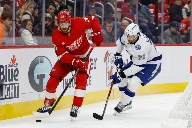 Jan 25, 2025; Detroit, Michigan, USA;  Detroit Red Wings left wing J.T. Compher (37) skates with the puck chased by Tampa Bay Lightning center Anthony Cirelli (71) in the second period at Little Caesars Arena. Mandatory Credit: Rick Osentoski-Imagn Images