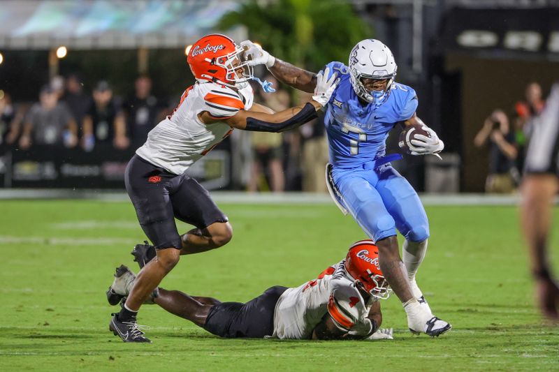 Nov 11, 2023; Orlando, Florida, USA; UCF Knights running back RJ Harvey (7) is pushed out of bounds by Oklahoma State Cowboys safety Cameron Epps (7) during the second half at FBC Mortgage Stadium. Mandatory Credit: Mike Watters-USA TODAY Sports