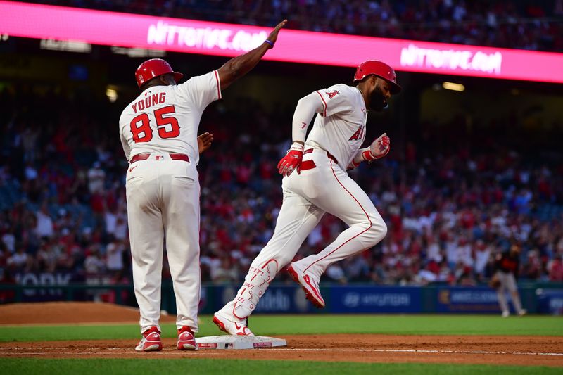 May 10, 2025; Anaheim, California, USA; Los Angeles Angels right fielder Jo Adell (7) is greeted by first base coach Eric Young Sr. (85) after hitting a solo home run against the Baltimore Orioles during the fourth inning at Angel Stadium. Mandatory Credit: Gary A. Vasquez-Imagn Images
