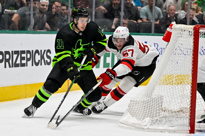 Mar 14, 2024; Dallas, Texas, USA; New Jersey Devils defenseman Nick DeSimone (57) attempts to knock the puck away from Dallas Stars center Logan Stankoven (11) during the second period at the American Airlines Center. Mandatory Credit: Jerome Miron-USA TODAY Sports