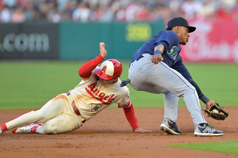 Jul 13, 2024; Anaheim, California, USA;  Mickey Moniak #16 of the Los Angeles Angels beats the throw to Jorge Polanco #7 of the Seattle Mariners for a stolen base in the second inning at Angel Stadium. Mandatory Credit: Jayne Kamin-Oncea-USA TODAY Sports