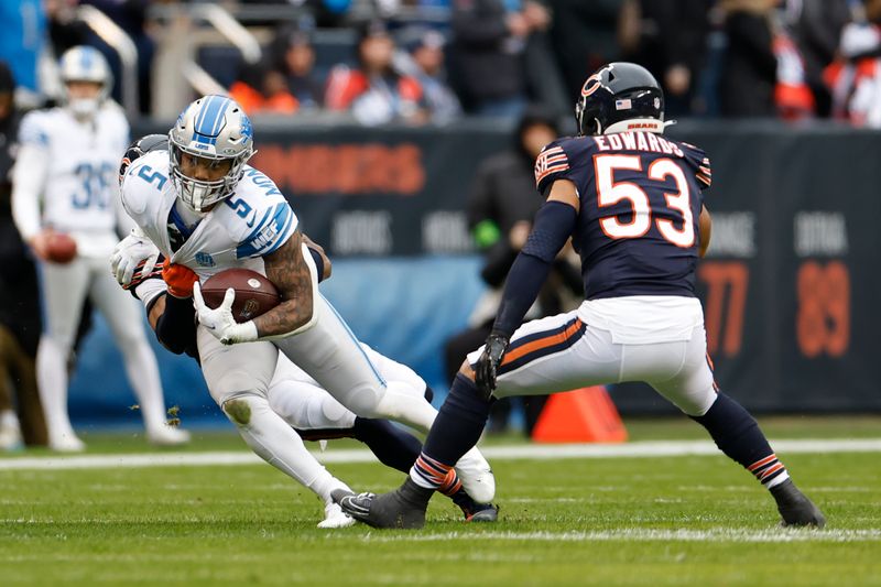 Chicago Bears safety Jaquan Brisker (9) tackles Detroit Lions running back David Montgomery (5) during the first half of an NFL football game, Sunday, Dec. 10, 2023, in Chicago. (AP Photo/Kamil Krzaczynski)