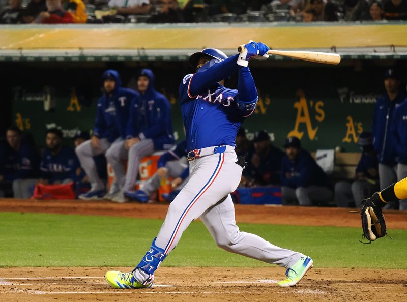 Sep 25, 2024; Oakland, California, USA; Texas Rangers right fielder Adolis Garcia (53) hits a two-run home run against the Oakland Athletics during the third inning at Oakland-Alameda County Coliseum. Mandatory Credit: Kelley L Cox-Imagn Images