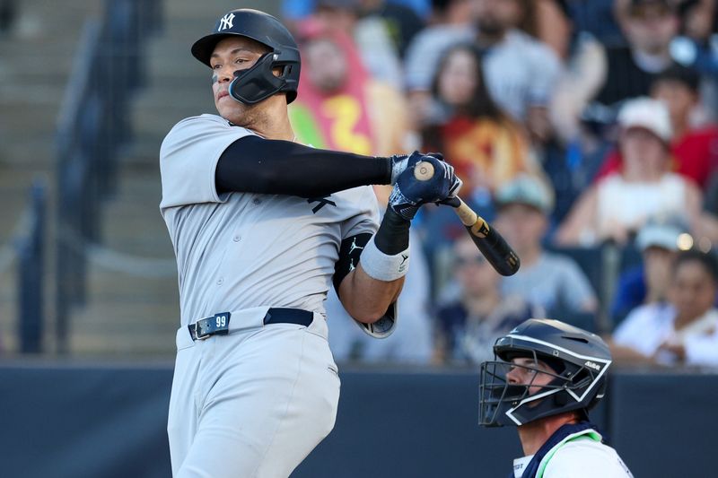 Apr 19, 2025; Tampa, Florida, USA; New York Yankees right fielder Aaron Judge (99) hits an rbi single against the Tampa Bay Rays in the ninth inning at George M. Steinbrenner Field. Mandatory Credit: Nathan Ray Seebeck-Imagn Images